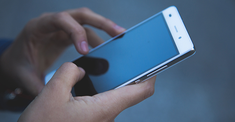 Två händer håller i en mobiltelefon