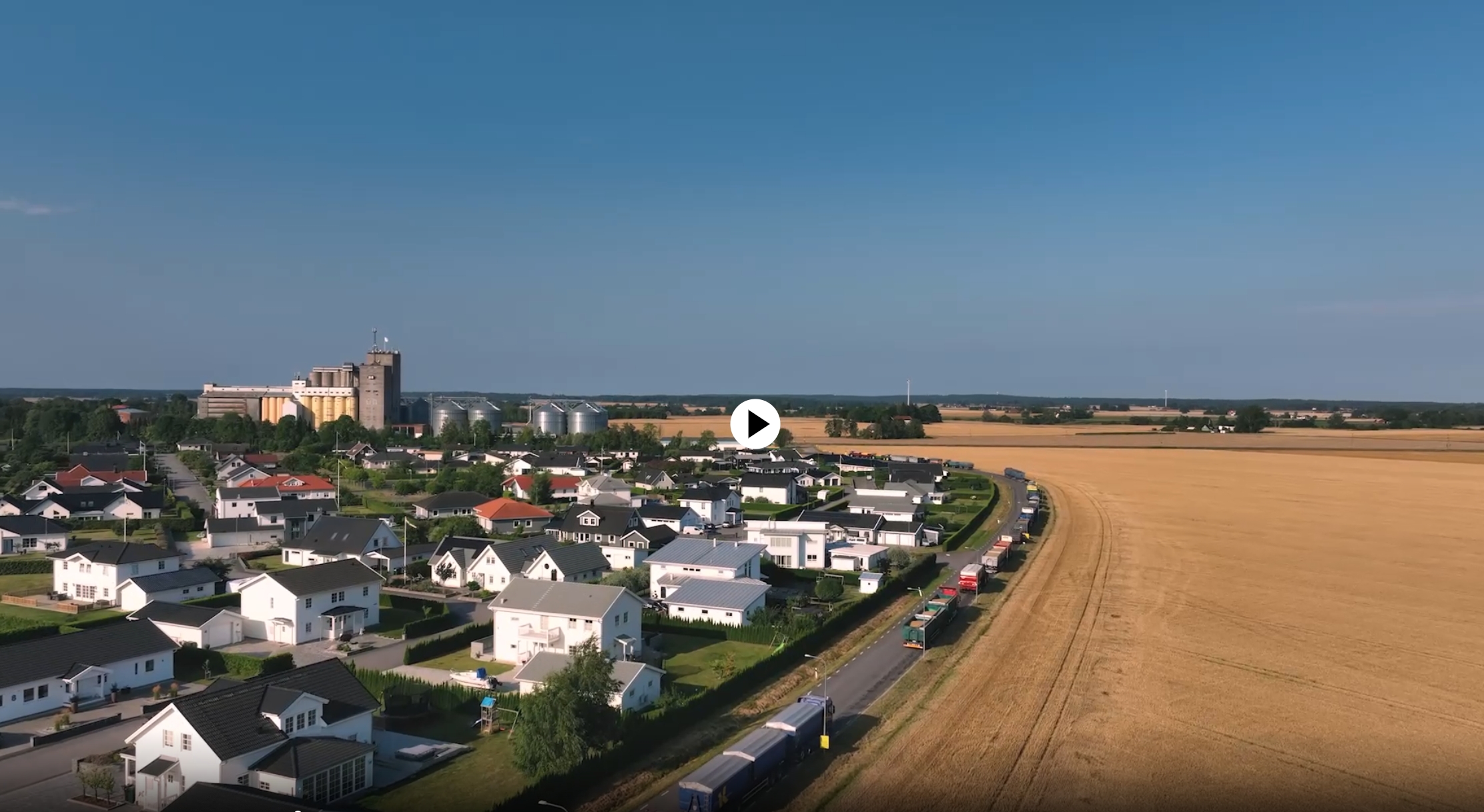 Flygbild över Vara kommun. Orten till vänster i bild och sädesfält till höger. En klar sensommardag.